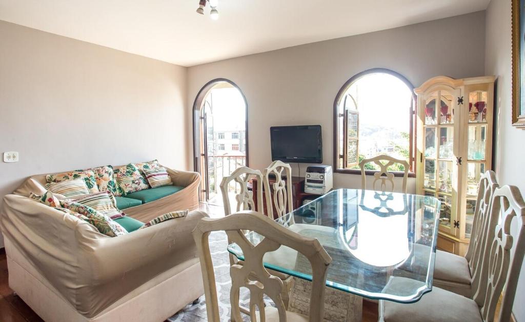 a living room with a couch and a glass table at Cobertura com piscina privativa próxima à praia in Cabo Frio