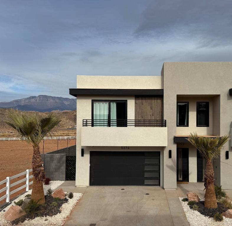 a house with a garage and two palm trees at Wild West Oasis - Experienced Hosts, 2 King Suites in Hurricane