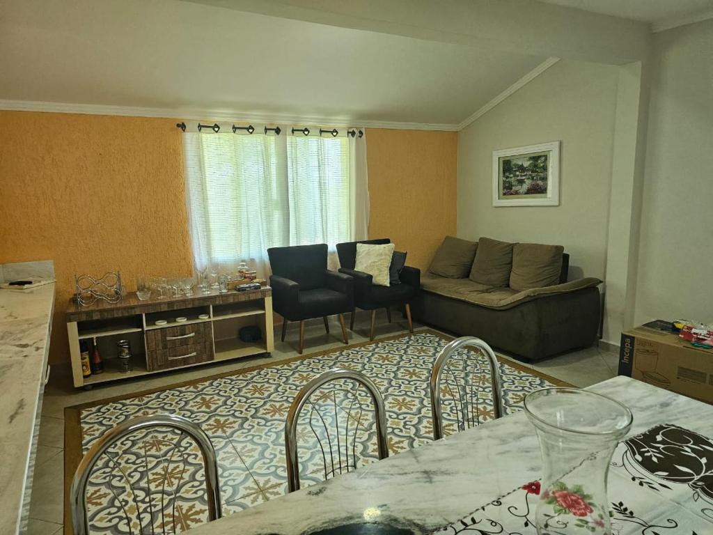 a living room with a couch and a table and chairs at Chácara 2 irmãos in São Pedro