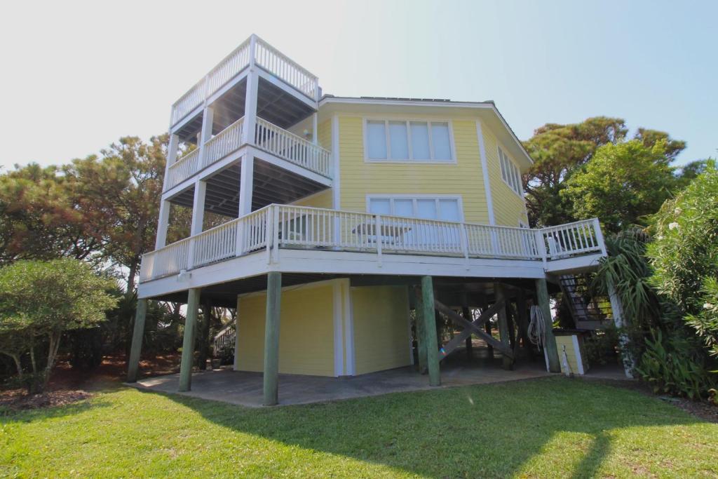 ein gelbes Haus mit einer Veranda und einem Balkon in der Unterkunft 1505 Forrest in Folly Beach