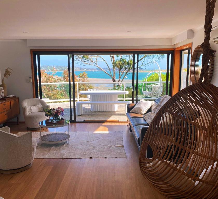 a living room with a couch and a swing at Seagrass Coastal Retreat with direct beach access in Lewisham