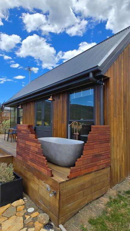 a bath tub sitting on the deck of a house at Appledore - Cabin in the Valley in Glen Huon