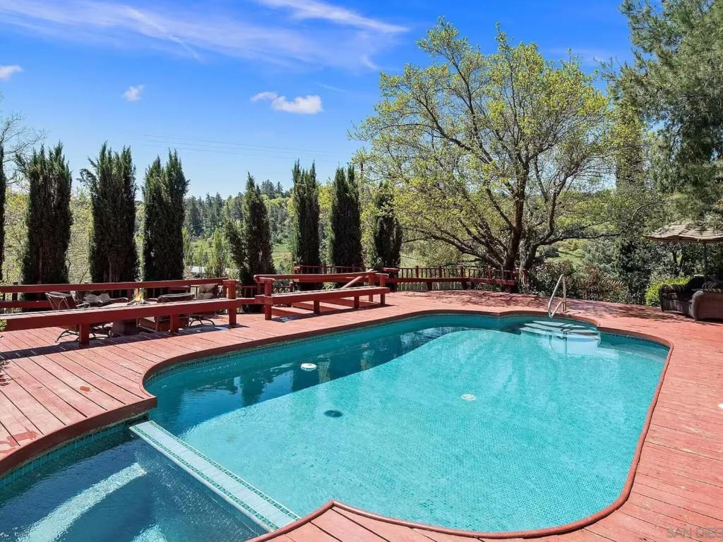 una piscina en un patio con bancos alrededor en Autumn Room at Eaglenest Inn with Pool and SPA, en Julian