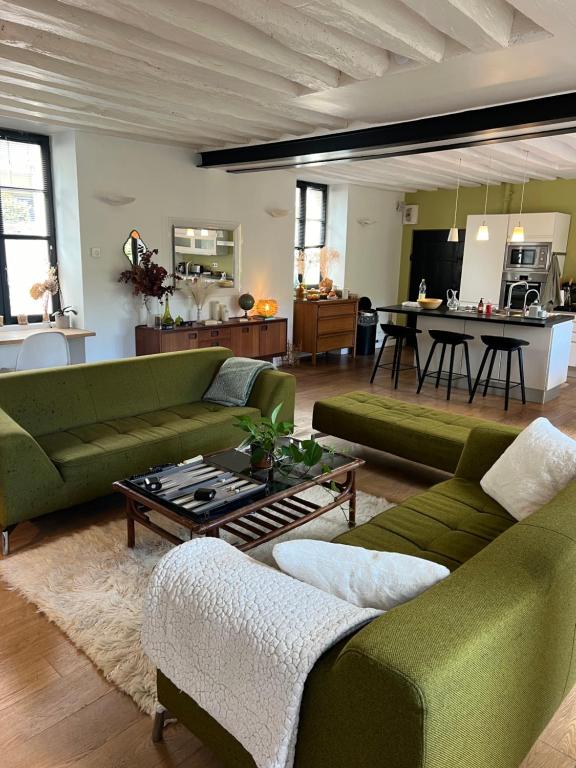 - un salon avec deux canapés verts et une table dans l'établissement Maison de charme dans le vieux Marly, à Marly-le-Roi