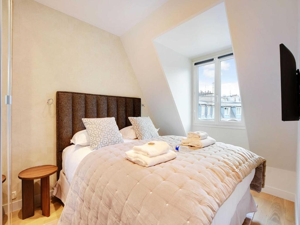 une chambre avec un lit avec des serviettes dessus dans l'établissement Cozy flat - 1BR 3P, à Paris