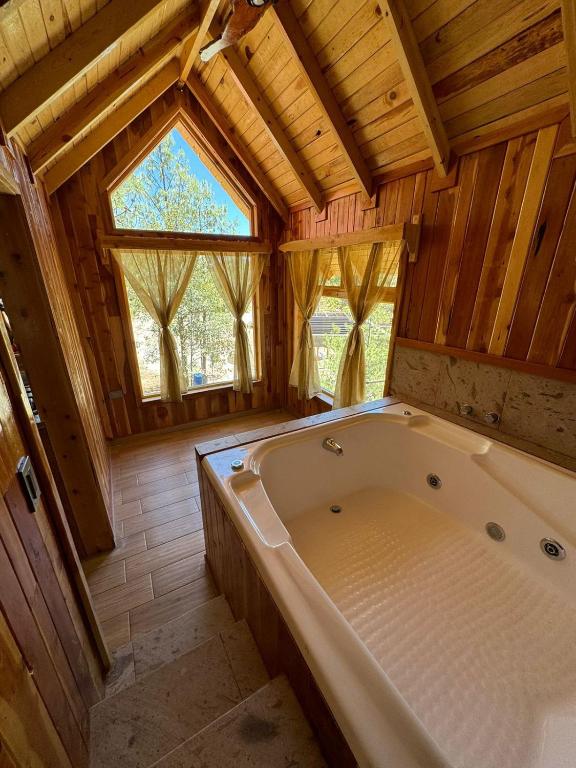a large bath tub in a room with wooden walls at Grand Mountain Cabañas Creel in Creel