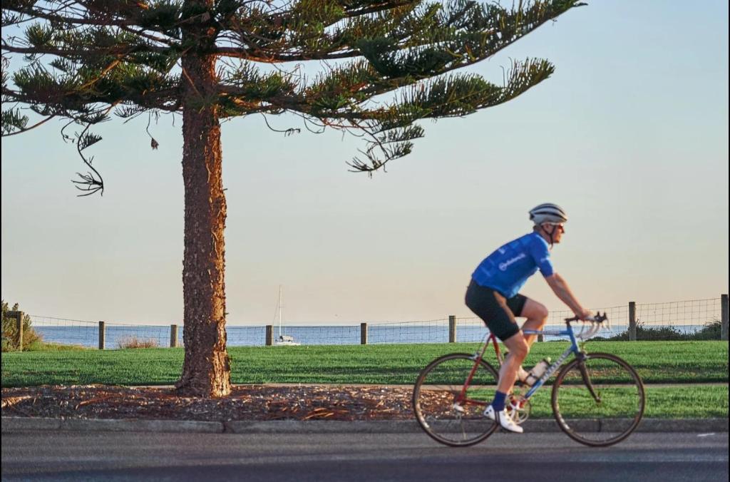 a man riding a bike down a street at Classy Spaces Keysborough - New 2 Storey Townhouse in Keysborough