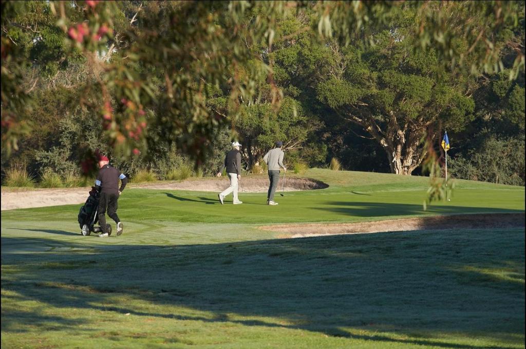 a group of people playing golf on a golf course at Classy Spaces Keysborough - New 2 Storey Townhouse in Keysborough