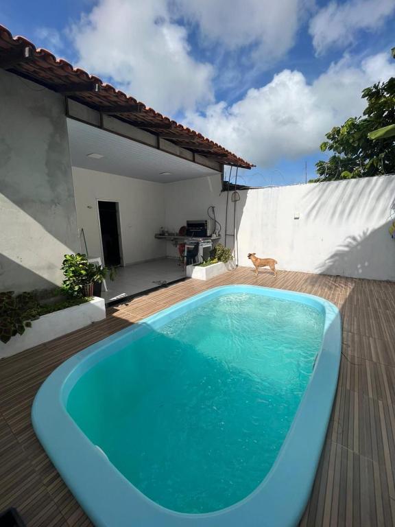 a blue swimming pool in front of a house at Casa Salinopolis in Salinópolis
