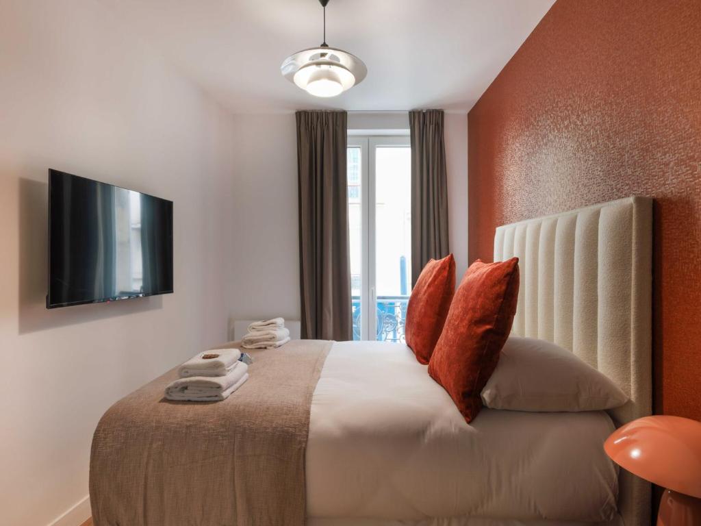 une chambre avec un lit avec une télévision au mur dans l'établissement Magnificent apartment - 4BR 10P - Arc de Triomphe, à Paris