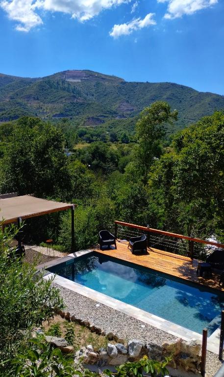 a swimming pool with a deck and a view of mountains at Refugio del Valle in La Falda