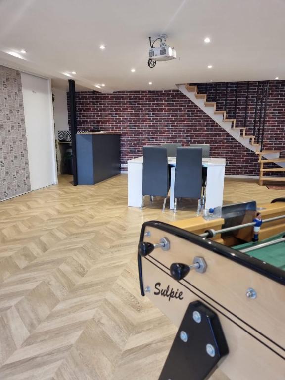 Cette chambre comprend une table de ping-pong et des chaises. dans l'établissement Marafiki Etretat, à Percoq