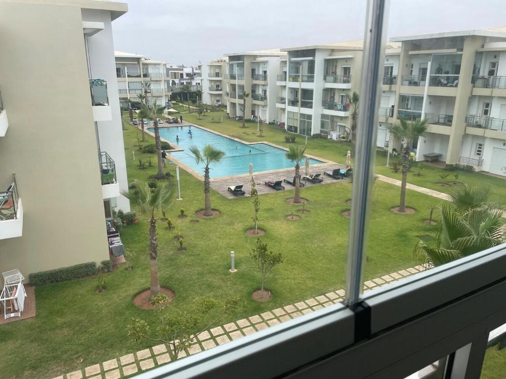a view from a window of a pool and palm trees at À LOUER APPARTEMENT à Casabay in Sidi Rahal