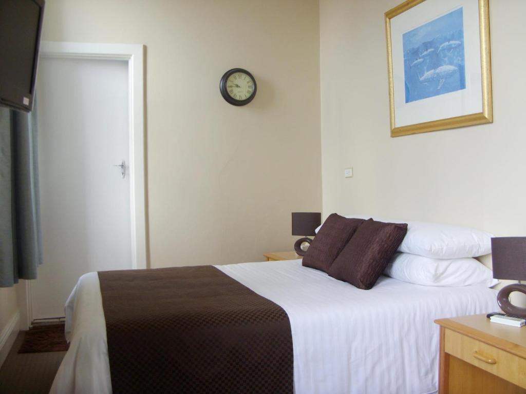 CollieにあるThe Colliefields Hotelのベッドルーム1室(壁に時計付)