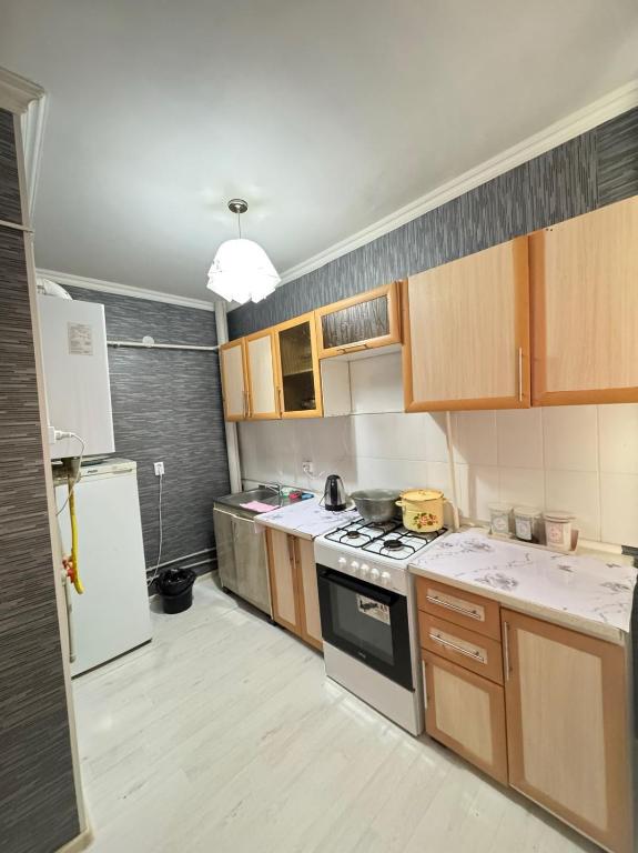 una cucina con fornelli e frigorifero di Квартира посуточно жана кала a Tridtsatʼ Let Kazakhstana