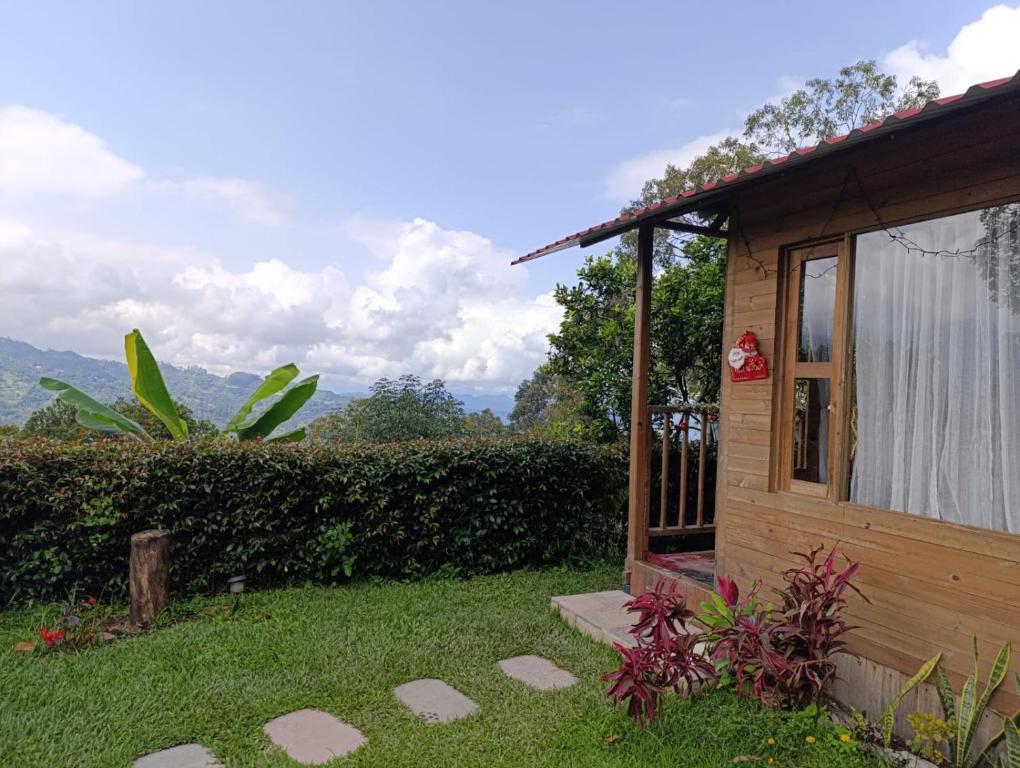 a small wooden house with a window and green grass at Cabaña Luz de Luna in San Francisco
