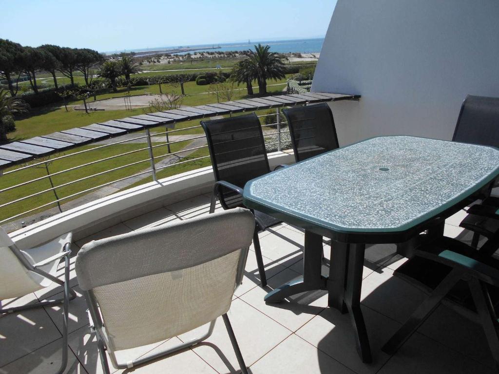 une table et des chaises sur un balcon avec vue dans l'établissement Port Camargue, Appartement 2 Pièces Climat. avec Terrasse Vue Mer - FR-1-731-127, au Grau-du-Roi