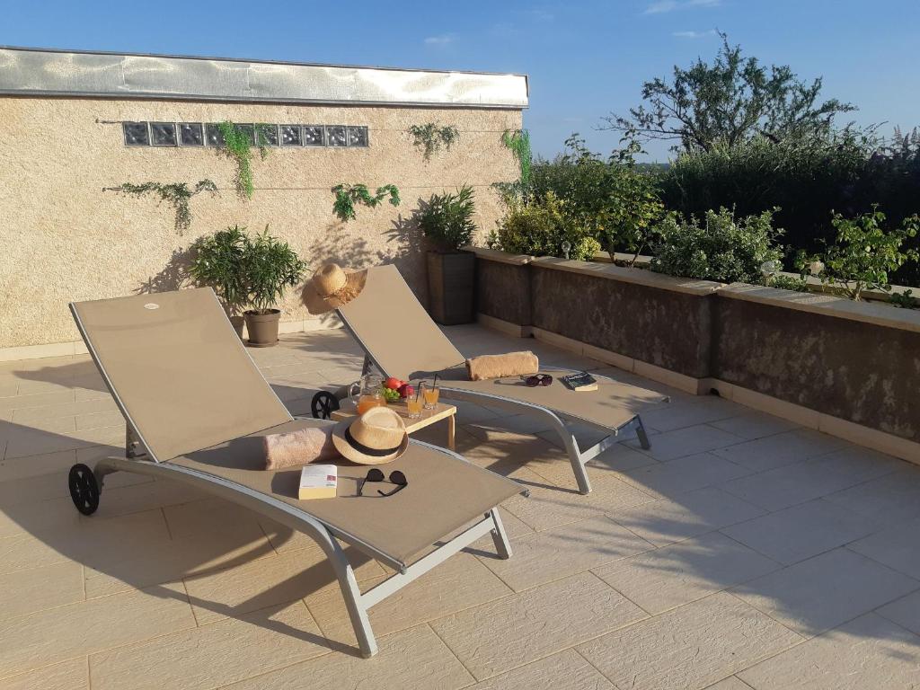 deux chaises et une table sur une terrasse dans l'établissement Appartement lumineux rénové, près de Nancy - FR-1-584-372, à Sexey-les Bois