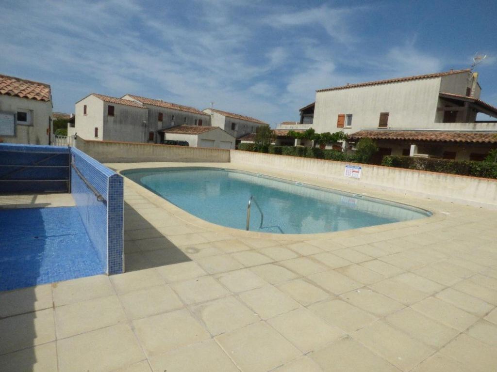 une piscine au milieu d'un immeuble dans l'établissement Appartement 4 pers aux Saintes-Maries-de-la-Mer avec Cour et Parking - FR-1-475-150, à Saintes-Maries-de-la-Mer