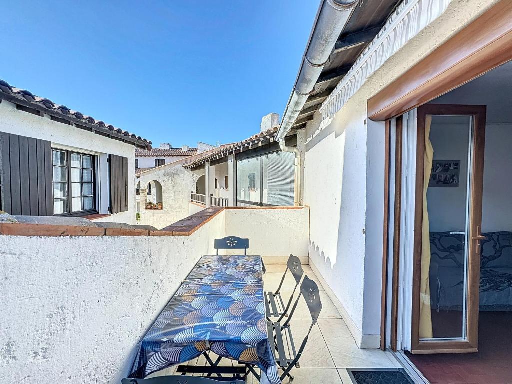 un patio avec une table et des chaises sur un balcon dans l'établissement Studio climatisé pour 4 pers, proche commerces - FR-1-475-151, à Saintes-Maries-de-la-Mer