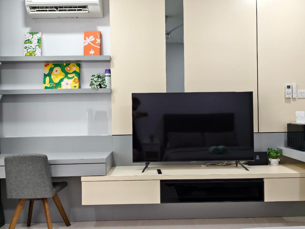 Una sala de estar con un televisor de pantalla plana sobre una mesa. en The Cozy Grey Riverine Diamond, en Kuching