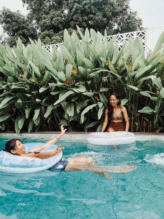 two women riding on inflatables in a swimming pool at 148 Guesthouse and Resort in Alaminos