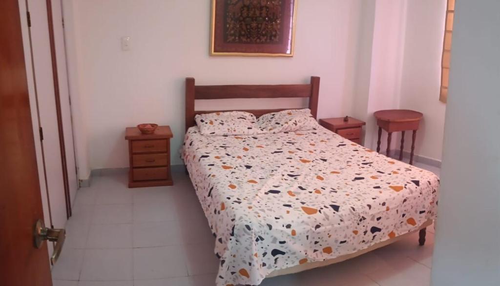 a bedroom with a bed with a comforter on it at residencias lalamar in Chichiriviche