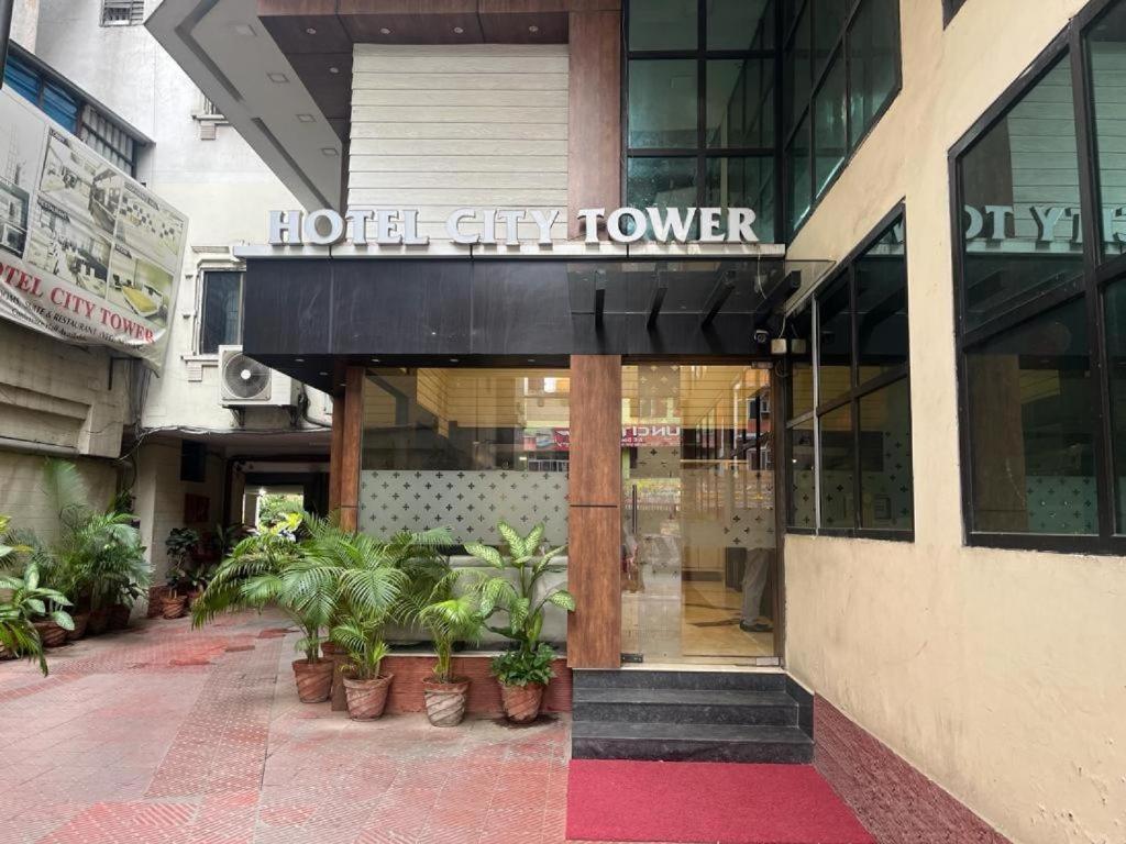 a hotel city tower with potted plants in front of it at Hotel City Tower, Chennai Central in Chennai