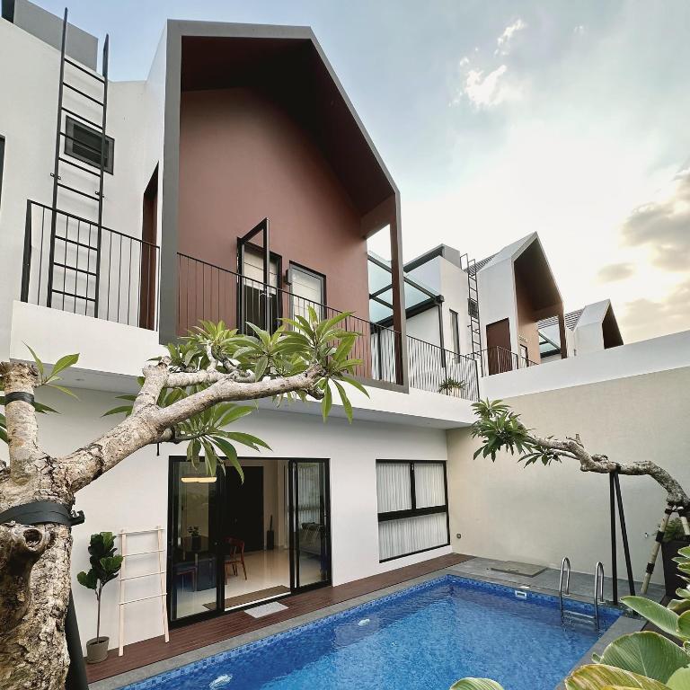an apartment building with a swimming pool in front of it at Cerita di Villa - Your Second Home in Batu in Tlekung