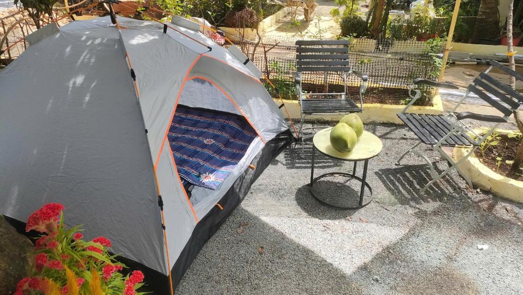 a tent and a table with a hat on it at Happy Farm Homestay in Ấp Long Ðại