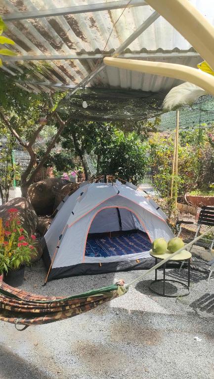 a tent sitting under an umbrella in a garden at Happy Farm Homestay in Ấp Long Ðại