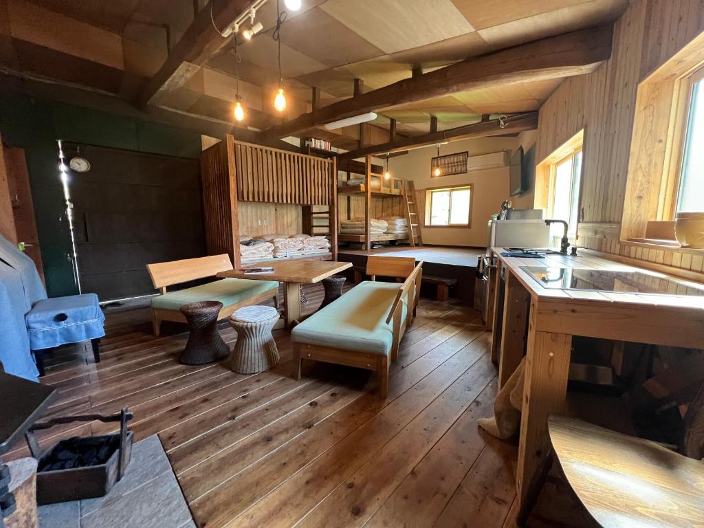 a room with wooden floors and a kitchen with a table at Ryuo Field in Kikuchi