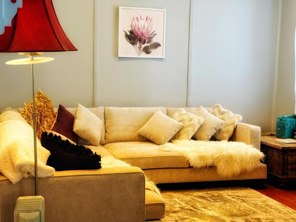 ein Wohnzimmer mit einem Sofa und Kissen in der Unterkunft Magnolia Cottage in Healesville