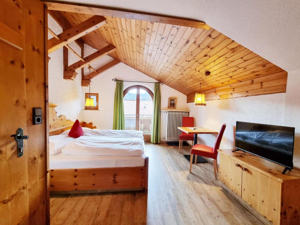a bedroom with a bed and a desk and a tv at Ferienhaus Goldenes Landl in Mittenwald