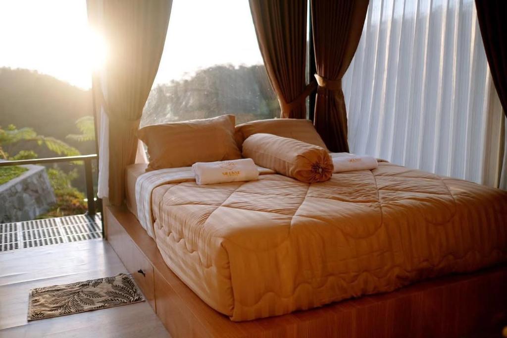 a bed sitting in a room with a window at Villane Tumpeng in Giripurno