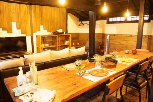 a dining room with a wooden table with chairs at Onjuku in Iwada