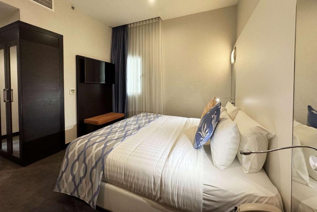 Voodi või voodid majutusasutuse Ramada Encore Doha by Wyndham toas