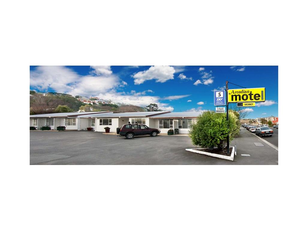 una señal de motel frente a un estacionamiento en Arcadian Motel, en Dunedin