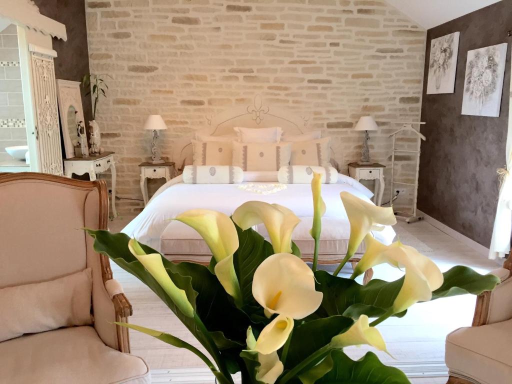 sypialnia z białym łóżkiem z żółtymi kwiatami w obiekcie Chambres d'hôtes Nuits Campagnardes w mieście Campagne-lès-Hesdin