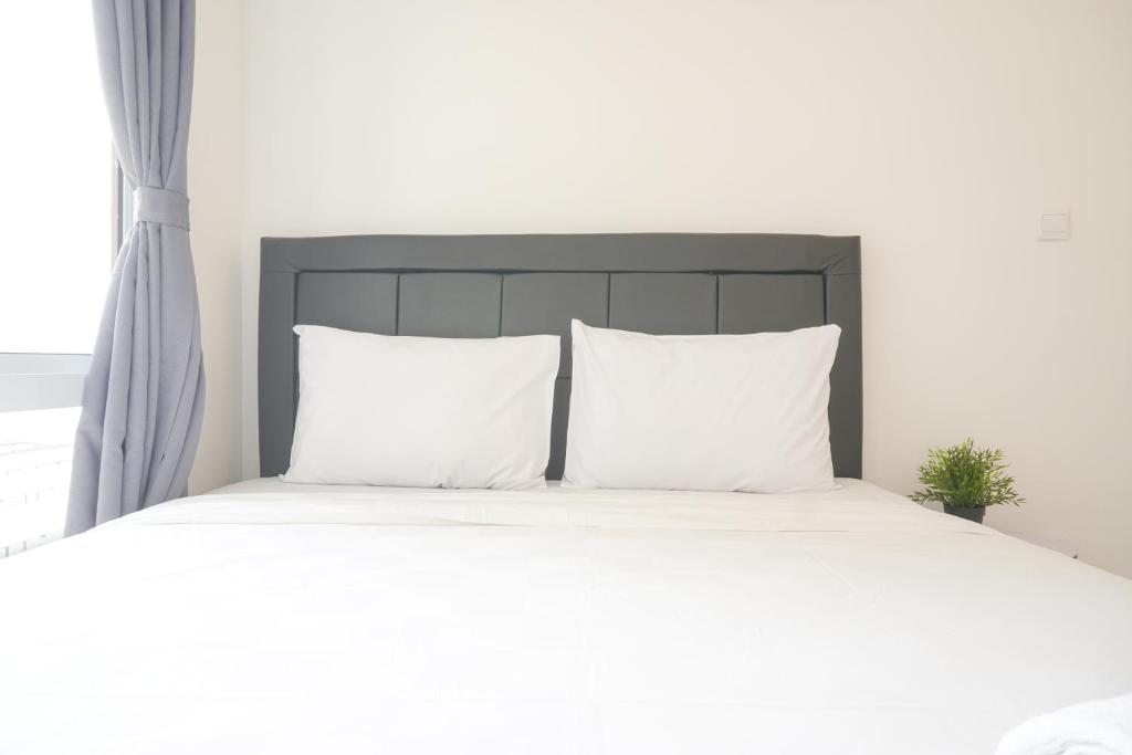 RawalembangNew Furnished and Spacious 2BR Tokyo Riverside PIK 2 Apartment By Travelio的一张带两个枕头的白色床和窗户