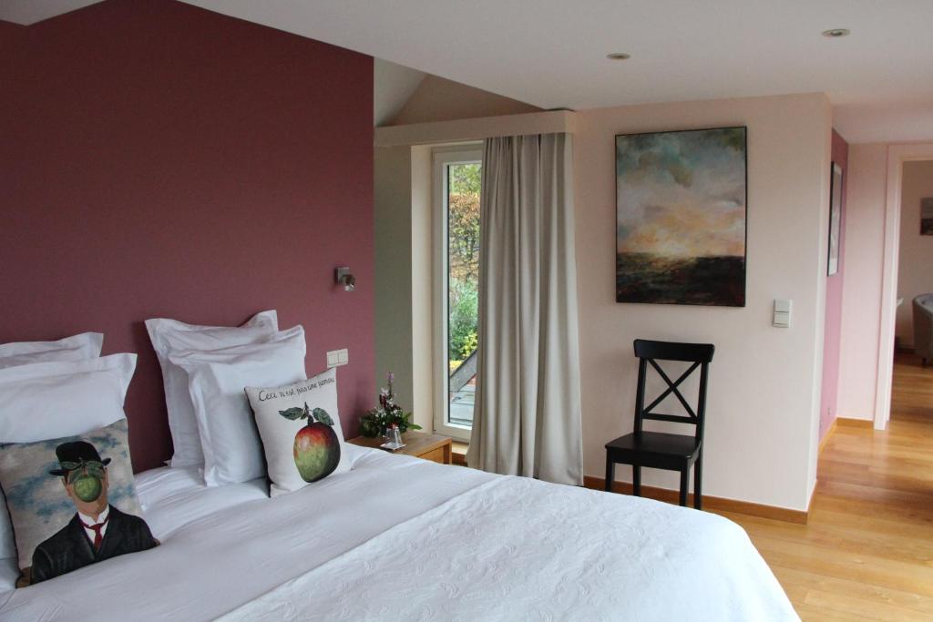 a bedroom with a large white bed with a window at Chambre d'hôtes CitaBel'Air in Namur