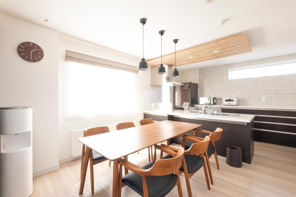 a kitchen and dining room with a wooden table and chairs at Tokuno Zoo Street in Asahikawa