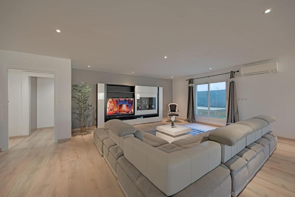 un grand salon avec un grand canapé et une cheminée dans l'établissement Loft Saint Roch - Spacieux - parking Gratuit, à Avignon