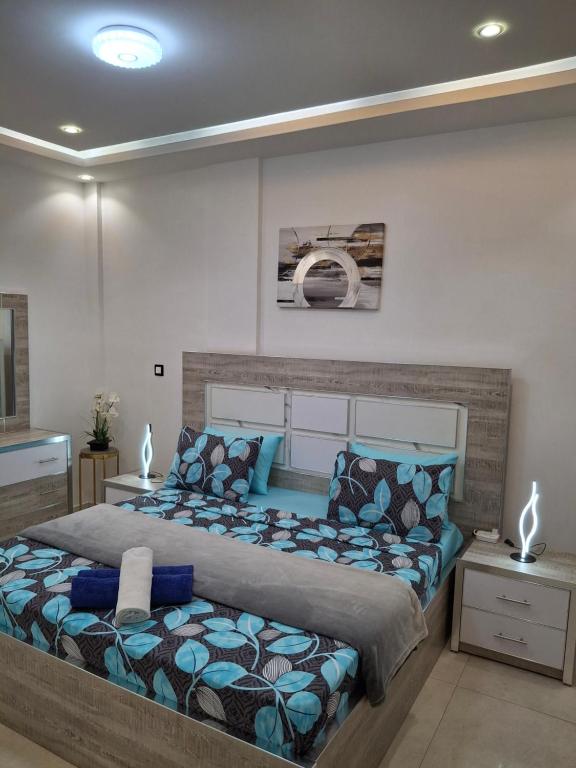 a bedroom with a large bed with blue pillows at Seckebe Immo et business DAKAR Suite 1 -gauche- in Dakar