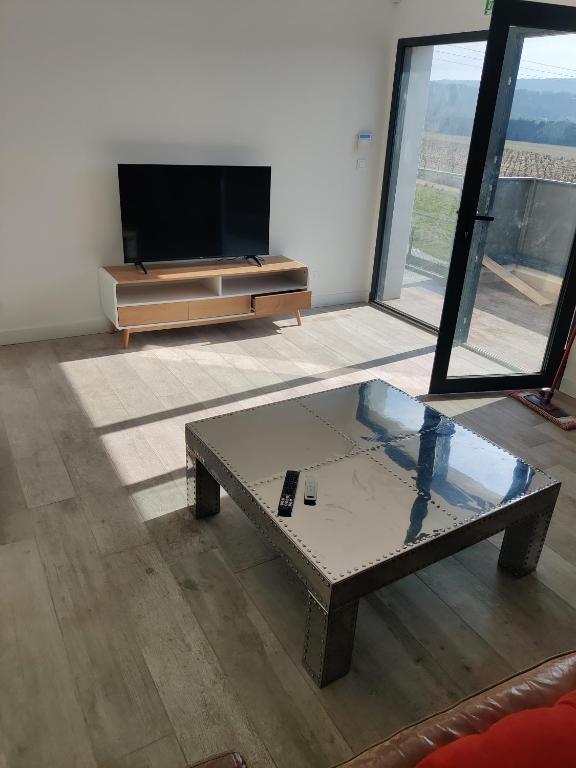 un salon avec une table basse et une télévision à écran plat dans l'établissement Location au calme, à Saint-Paul-Trois-Châteaux