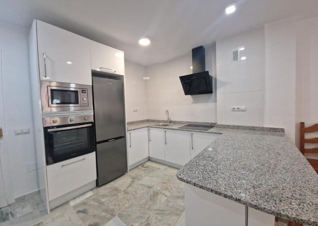 a kitchen with stainless steel appliances and granite counter tops at Castillo Apartament in Torremolinos