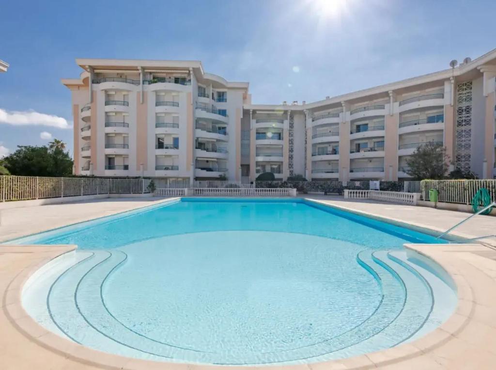 une grande piscine en face d'un grand bâtiment dans l'établissement Appartement confortable à Fréjus, 35 m² avec balcon agréable, à Fréjus