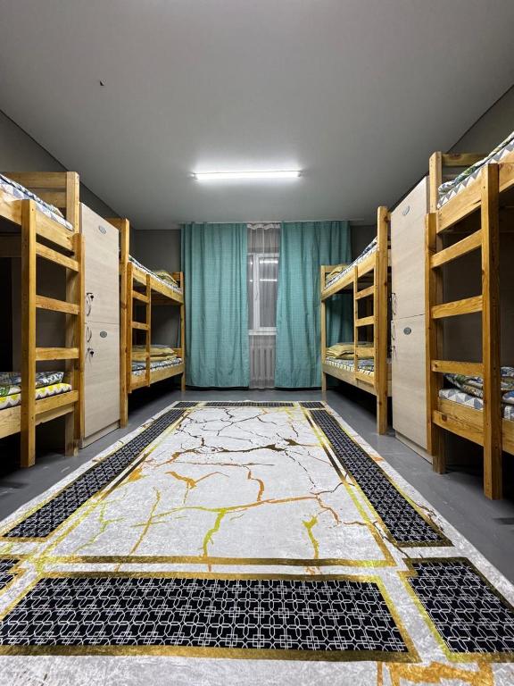 a room filled with bunk beds with a large rug at DelLuna in Almaty