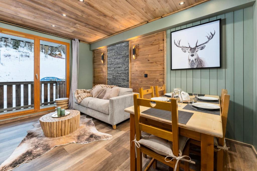 une salle à manger avec une table et un cerf sur le mur dans l'établissement Résidence Les Hauts De Preclaux - Appartement cocooning avec vue sur les pistes MAE-4551, aux Orres