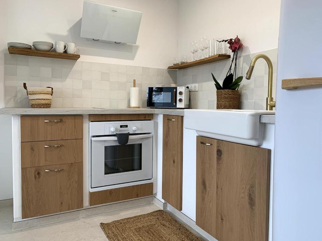 a kitchen with a sink and a stove at Appartement vue mer tout confort in Villeneuve-Loubet